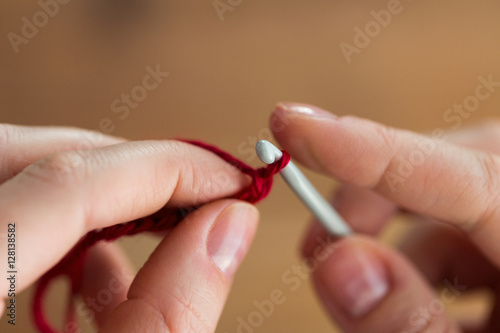 close up of hands knitting with crochet hook