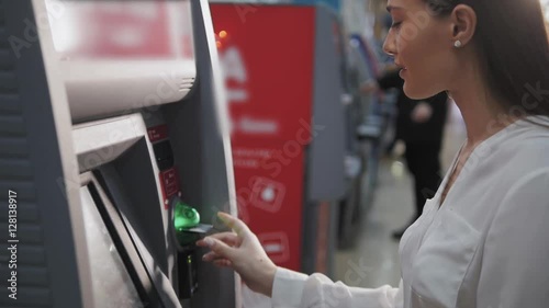 young woman inserting a credit card to ATM, beautiful girl banking