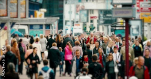 Crowd of People / Commuters Walking / Busy Street. Crowd on a busy street. People walk down a busy street with advertising, billboards, cars and public transport. Slow motion.