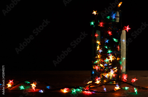 christmas lights in glass jar on wood, holiday background