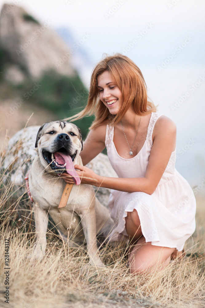 Young caucasian woman walking with dog during sunrise Young caucasian woman walking with dog during sunrise