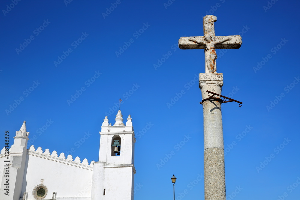 MERTOLA, PORTUGAL: The Matriz Church  (former Mosque of Mertola) with a religious cross in the foreground