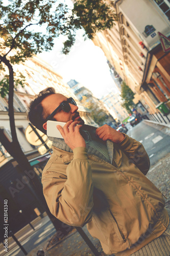Modern guy using smartphone in the European city.