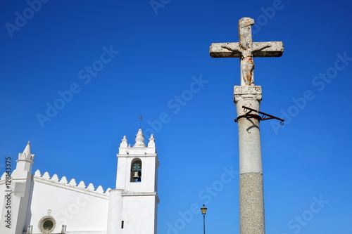 MERTOLA, PORTUGAL: The Matriz Church (former Mosque of Mertola) with a religious cross in the foreground