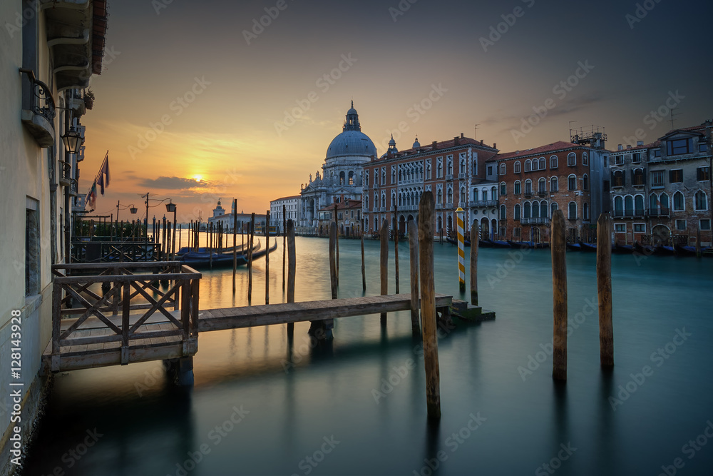 Amazing view of the Grand Canal and Basilica Santa Maria della Salute during sunrise with calm water, Venice, Italy