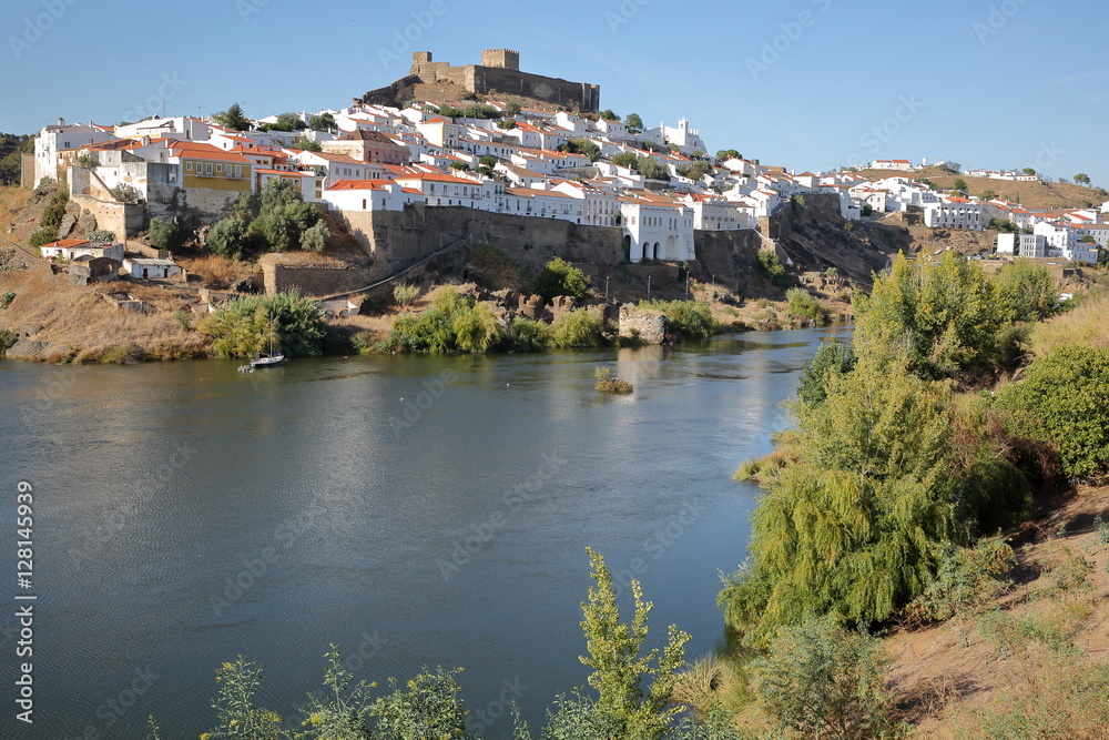 MERTOLA, PORTUGAL: General view of the fortified village from the opposite bank of the river Guadiana