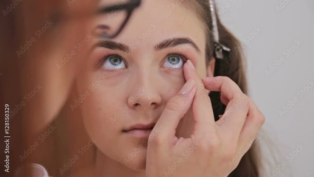Close up shot. Professional make-up artist applying cream base eyeshadow primer to model eye. Beauty, makeup and fashion concept Close up shot. Professional make-up artist applying cream base eyeshadow primer to model eye. Beauty, makeup and fashion concept