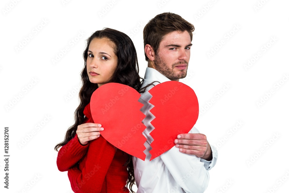 Couple back to back holding heart halves Couple back to back holding heart halves