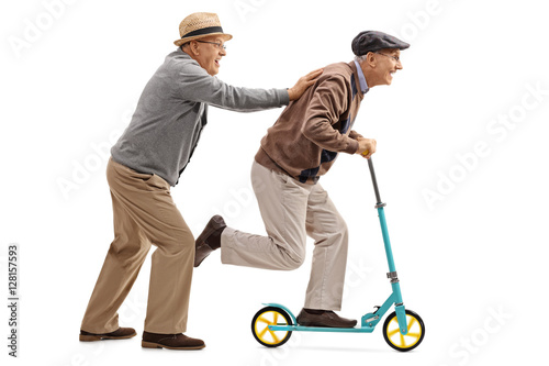 Mature man pushing another man on a scooter