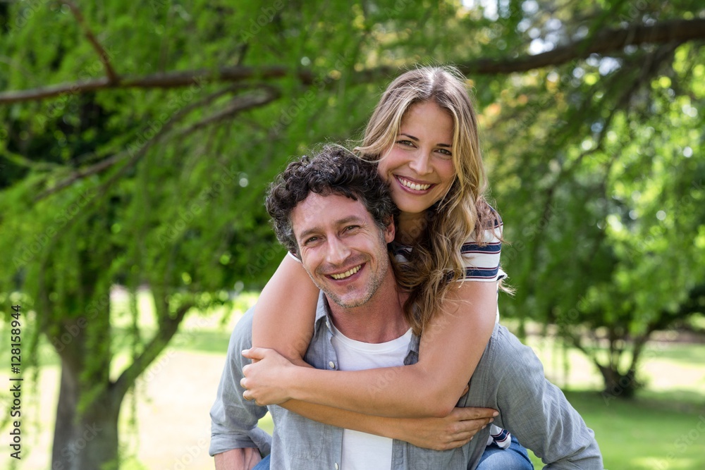 Husband giving a piggy-back to his wife Husband giving a piggy-back to his wife