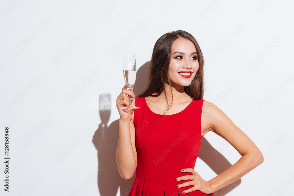 Happy beautiful young woman in red dress drinking champagne Happy beautiful young woman in red dress drinking champagne