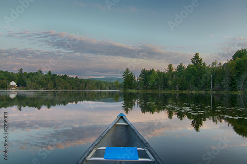 Canoeing on a calm lake in the morning in Quebec, Canada