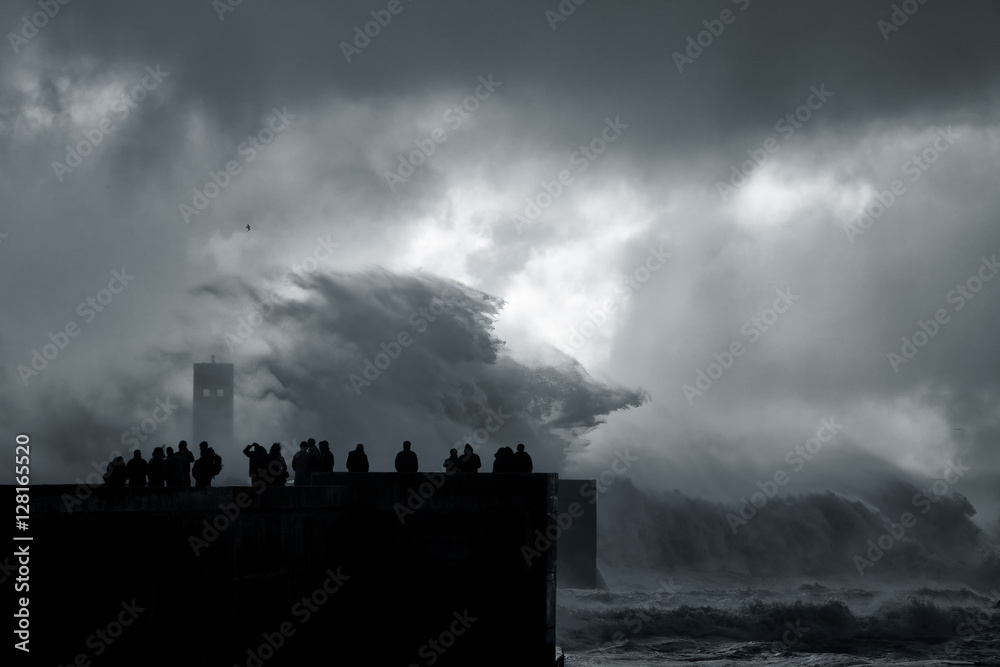 People silhouette looking at a sea storm