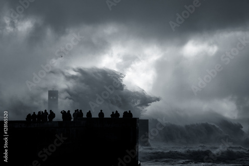 People silhouette looking at a sea storm