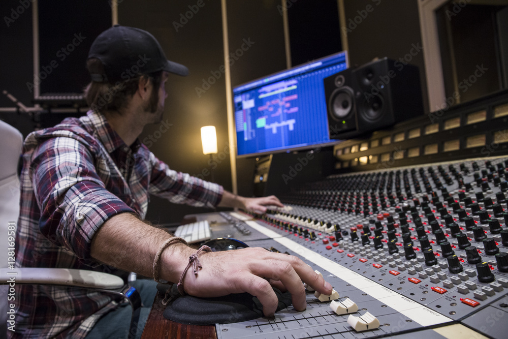 Man working in the control room of a recording studio Man working in the control room of a recording studio
