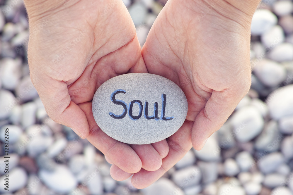 Woman holding stone with the word Soul in her palms Woman holding stone with the word Soul in her palms