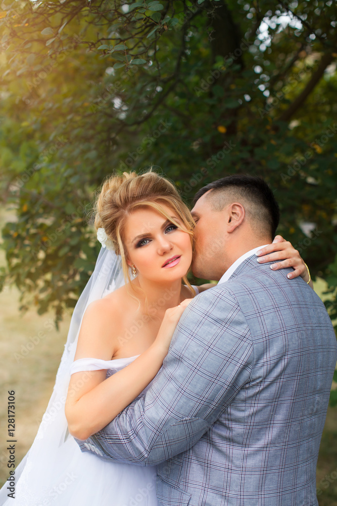 The groom tenderly kissing bride's neck