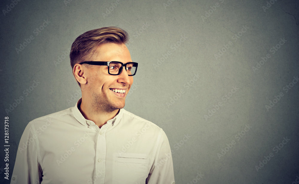 Young man with glasses smiling looking to the side Young man with glasses smiling looking to the side