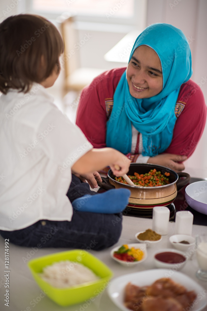 Muslim Arabic young mother and little cute son making food and h Muslim Arabic young mother and little cute son making food and h