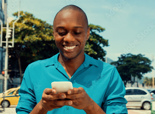 African american man surfing the internet by phone outdoor in a photo