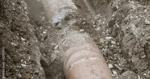 Old abndoned pipeline. Rusty pipe in trench half full of water photo