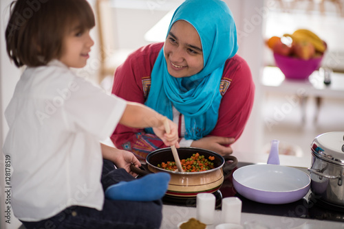 Muslim Arabic young mother and little cute son making food and h