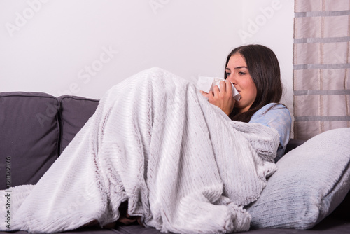 Obraz na płótnie junge Frau liegt krank  zuhause auf der Couch