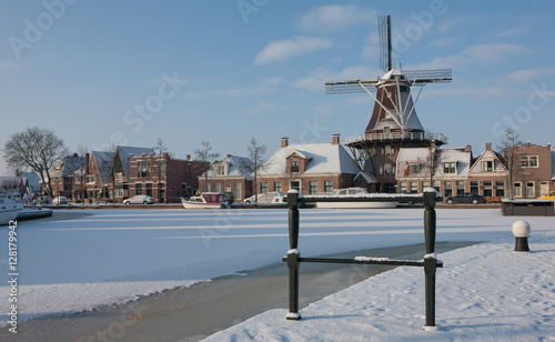 Traditional windmill in winter Meppel Drenthe Netherlands. Frozen canal Sluisgracht. Stoombootkade.