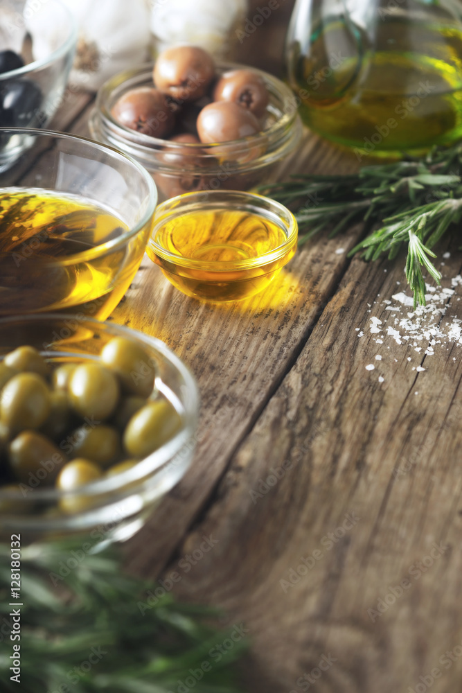 Olive oil and olives on the wooden table vertical Olive oil and olives on the wooden table vertical