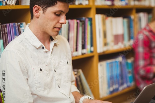 Concentrated male student working on floor