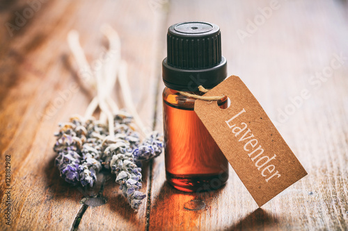 Lavender bunch and oil on wooden background photo