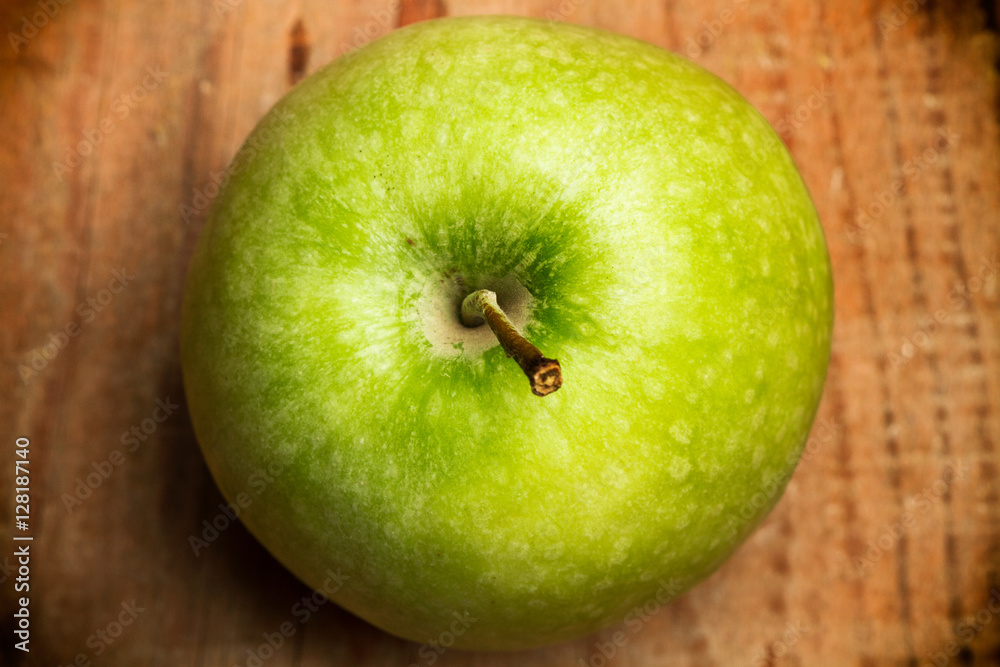 Manzana verde en primer plano sobre un fondo de madera rústico. Vista superior y de cerca Manzana verde en primer plano sobre un fondo de madera rústico. Vista superior y de cerca