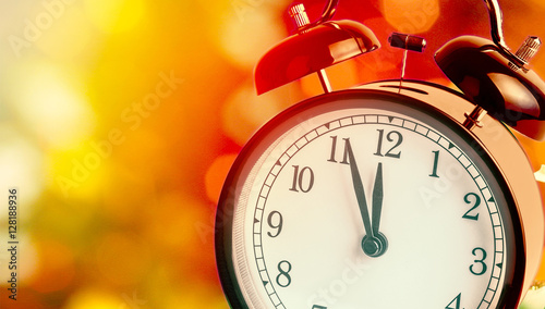 vintage alarm clock is showing midnight. It is twelve o'clock, christmas and bokeh, holiday happy new year festive concept