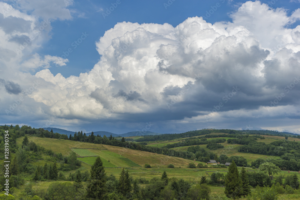 Naklejka premium Summer day landscape with road, cloudy sky and Mountains