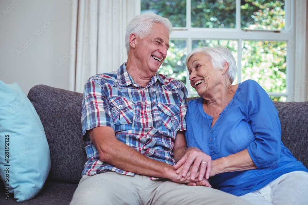 Happy senior couple holding hands at home Happy senior couple holding hands at home