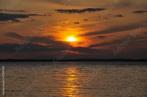 Distant cloudy sunset over huge lake