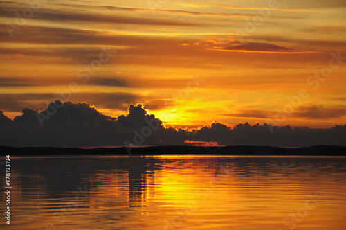 Distant cloudy sunset over huge lake