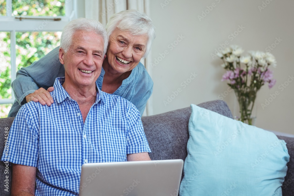 Portrait of smiling retired couple using laptop Portrait of smiling retired couple using laptop