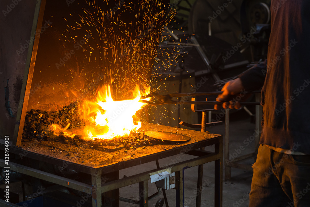 The blacksmith making flames in smithy The blacksmith making flames in smithy