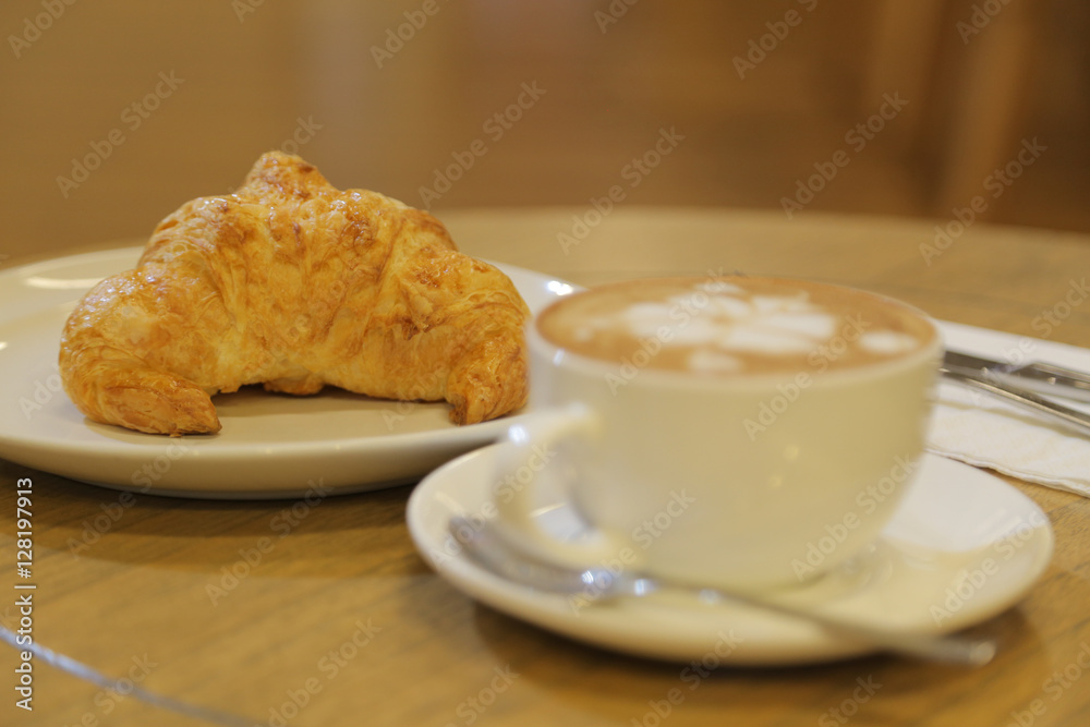 Breakfast with coffee latte art and croissant. Coffee break business Breakfast with coffee latte art and croissant. Coffee break business