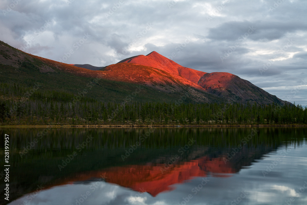 Mountain in the red light of sunset. Lake Labynkyr. Oimyakon Highlands. Yakutia. Russia.