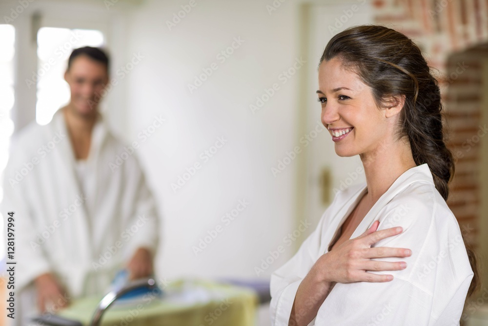 Obraz premium Beautiful woman in bathrobe looking away and smiling