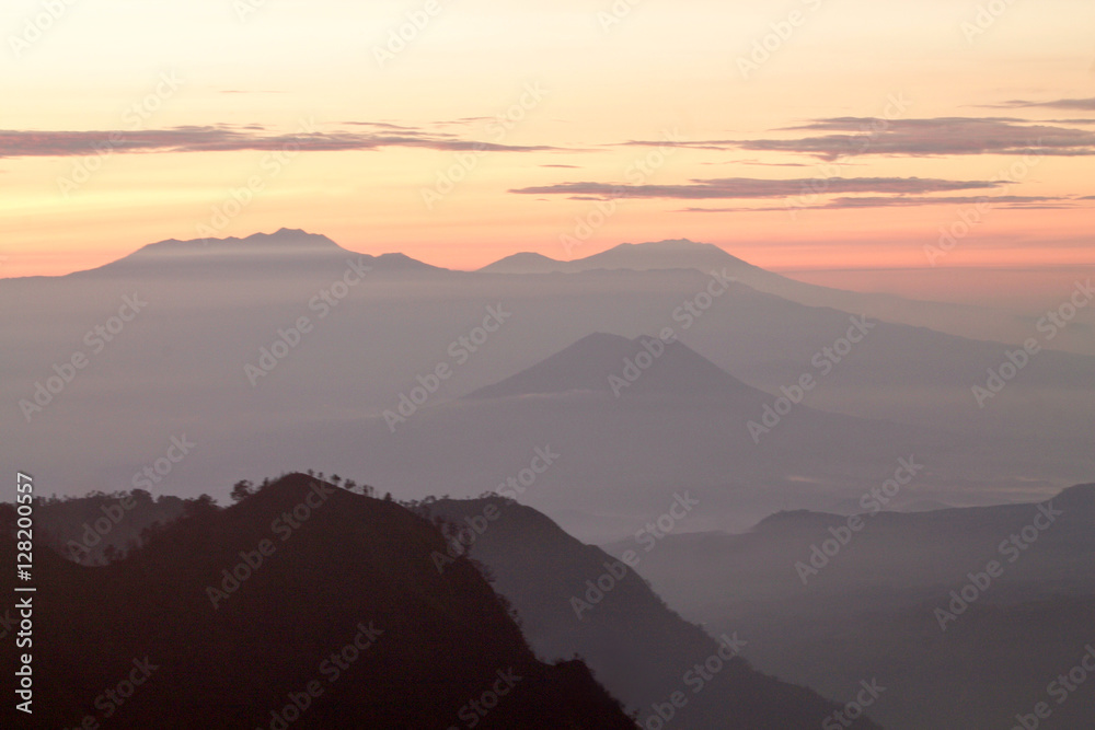 Naklejka premium silhouette of mountains in the fog at sunrise