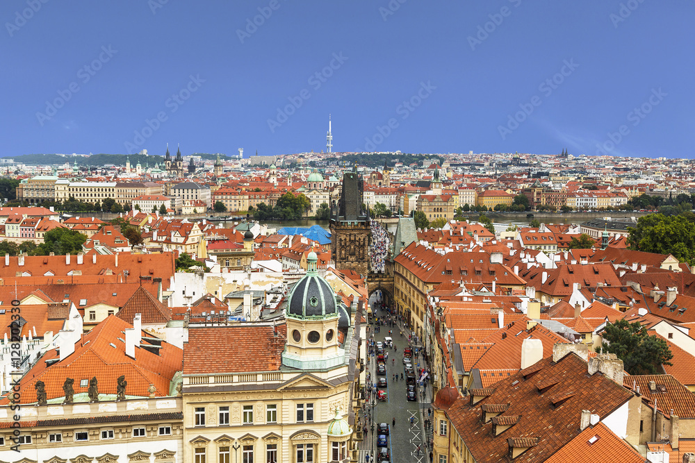 Panorama of Prague downtown with red roofs and Charles bridge tower