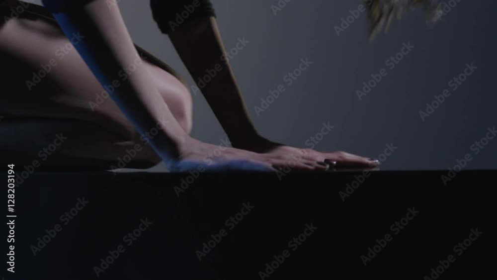 Sexy brunette dances on blue dark background. Beautiful girl dancing, laying on cube. Sexy brunette dances on blue dark background. Beautiful girl dancing, laying on cube.