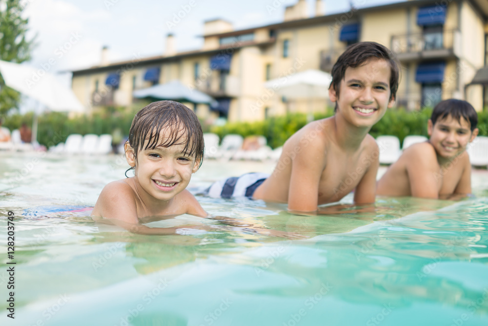 Young boy kid child splashing in swimming pool having fun leisur