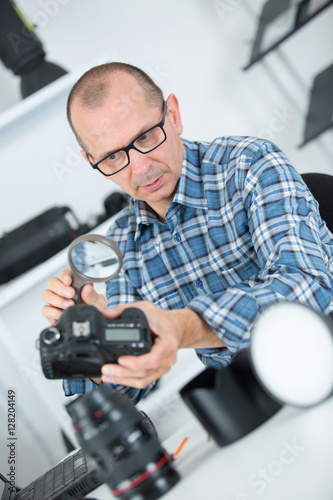 man checking photo in camera in office