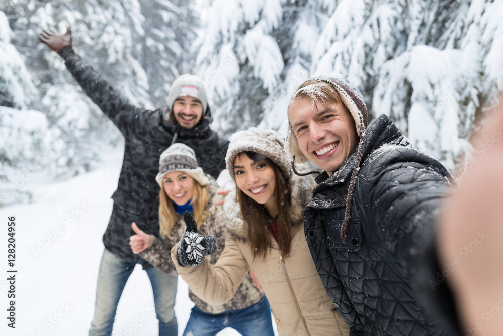 Obraz premium Man Taking Selfie Photo Friends Smile Snow Forest Young People Group Outdoor Winter Pine Woods