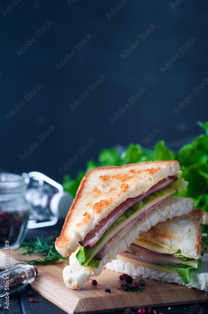 Club sandwich with a salad on a wooden plate