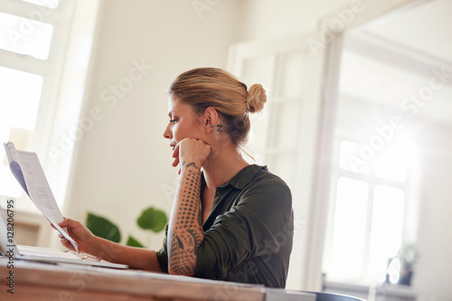 Woman going through contract papers at home office